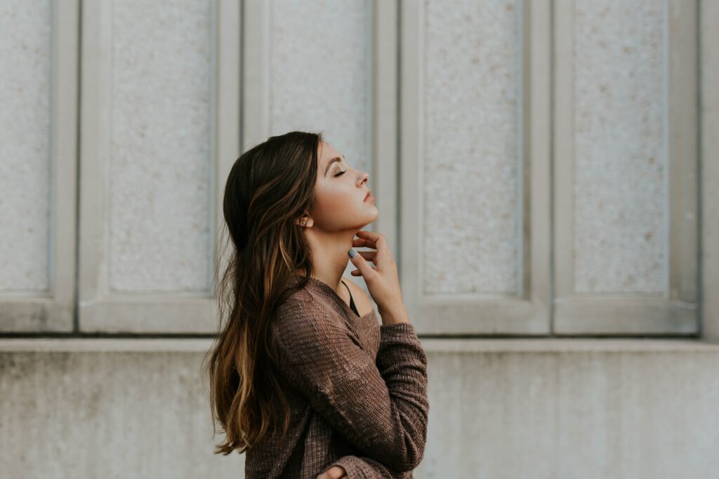 Adult woman with her head up and eyes closed wanting to find anxiety relief for adults.