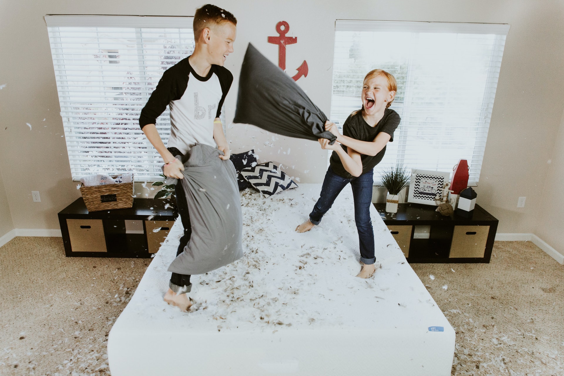 Two young boys having a pillow fight leading their parents to wonder how to stop feeling overwhelmed.