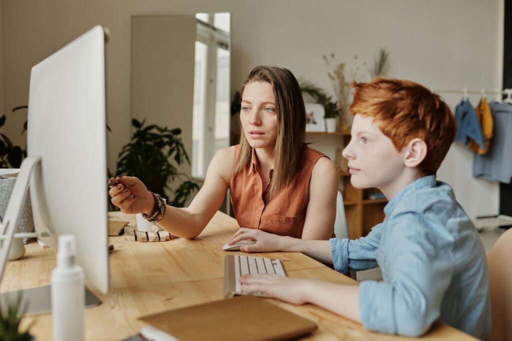 mom parenting during a pandemic by helping her son with virtual learning at home.