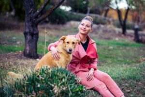 Smiling woman outside playing with her dog which is one of the stress and anxiety relief tips