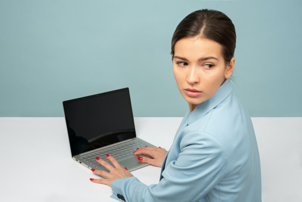Women in in front of computer looking over her shoulder dealing with return to work anxiety after Covid-19