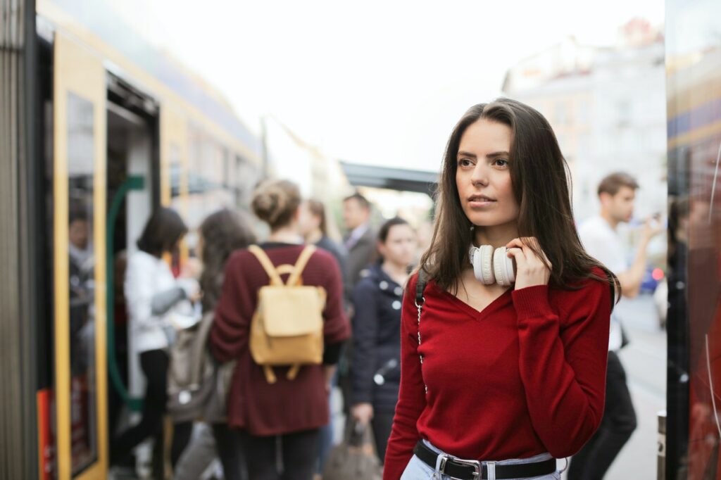 Anxious looking woman wearing a red shirt in a crowd wanting the best way to calm her anxiety.