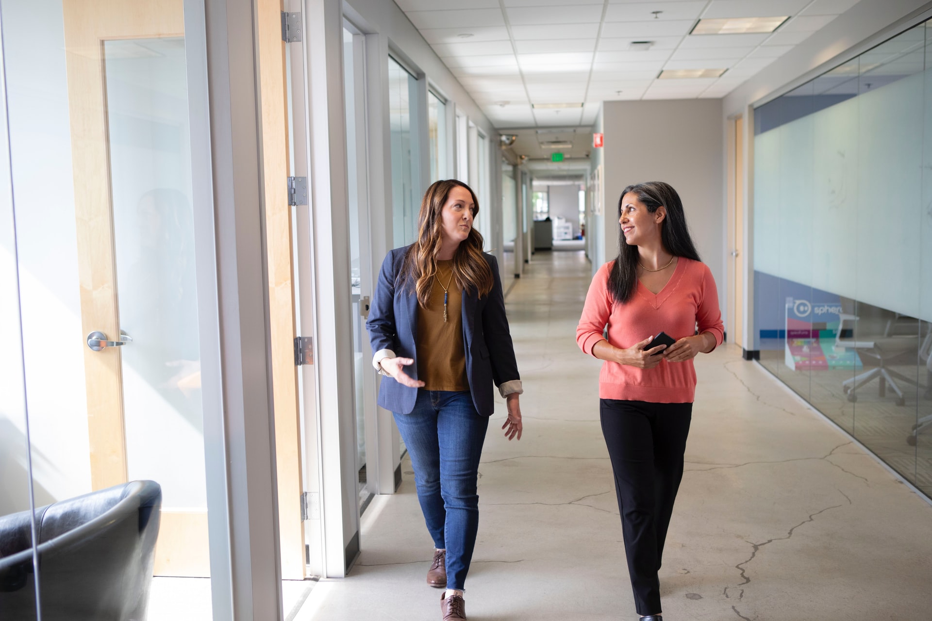 Two female co-workers taking a walking break to reduce stress at work.