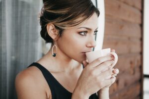 Woman sipping herbal tea as a calming exercise for anxiety.