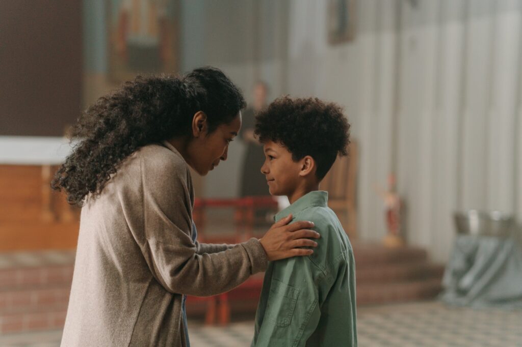 Black mom talking to her young son trying to help her child's anxiety.