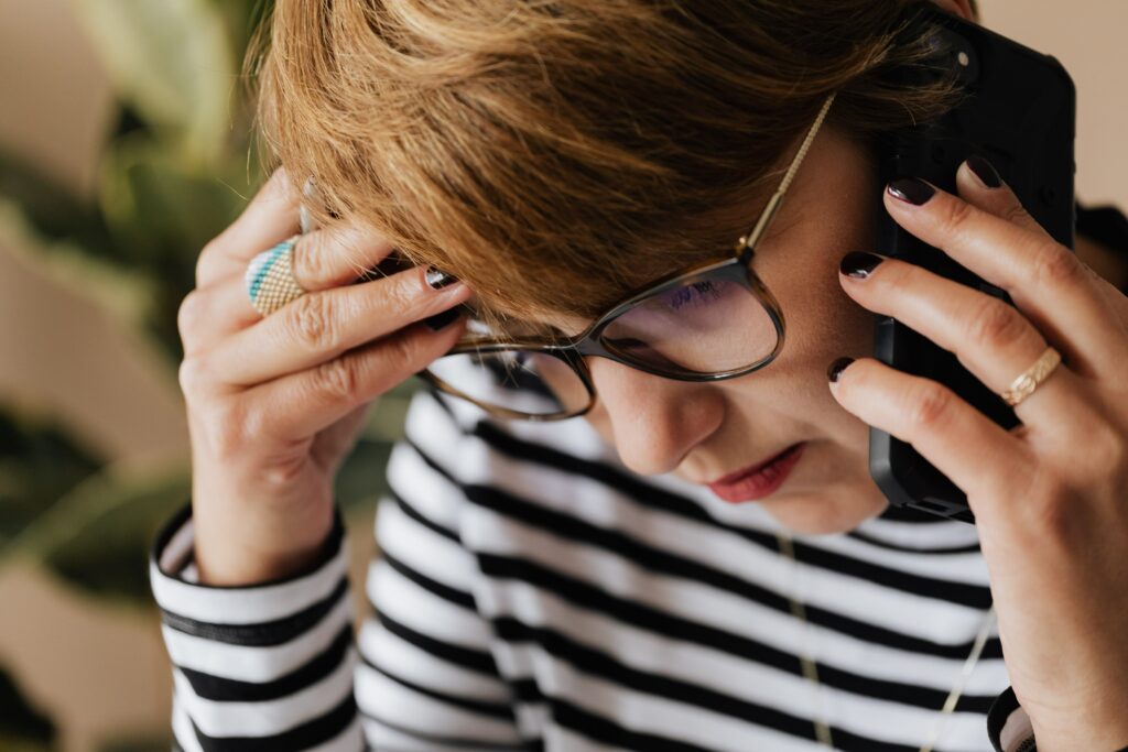 Anxious woman on phone wondering how to be less stressed at work