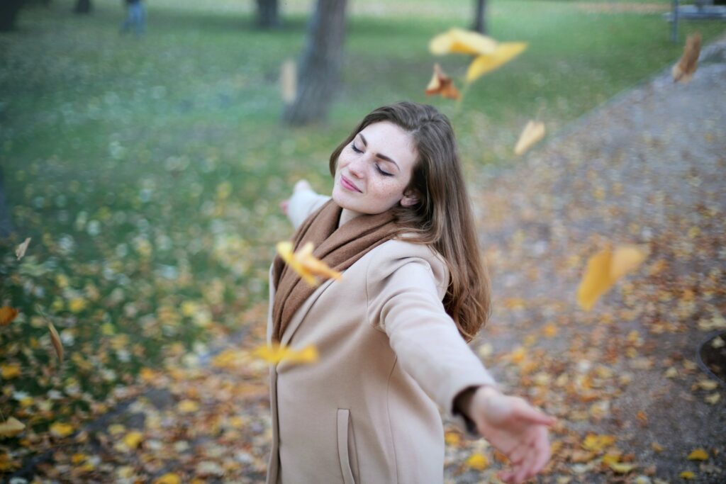 Smiling woman finding anxiety & stress relief outdoors.