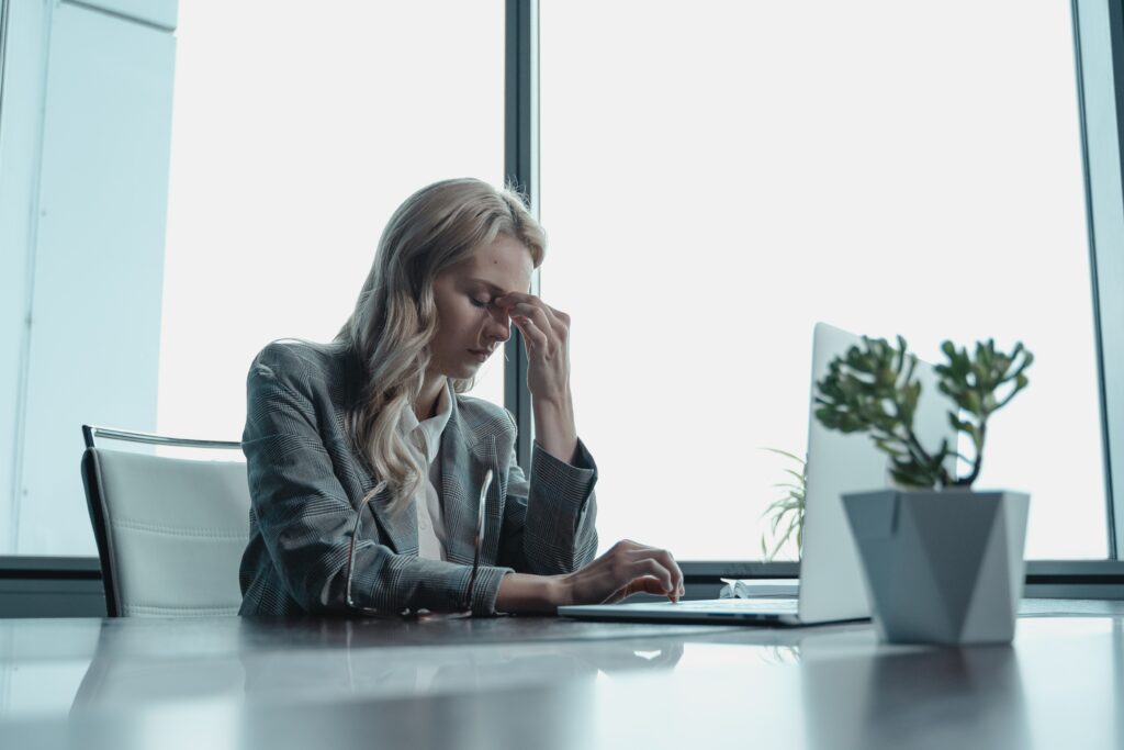 Anxious looking woman having an anxiety attack at work.