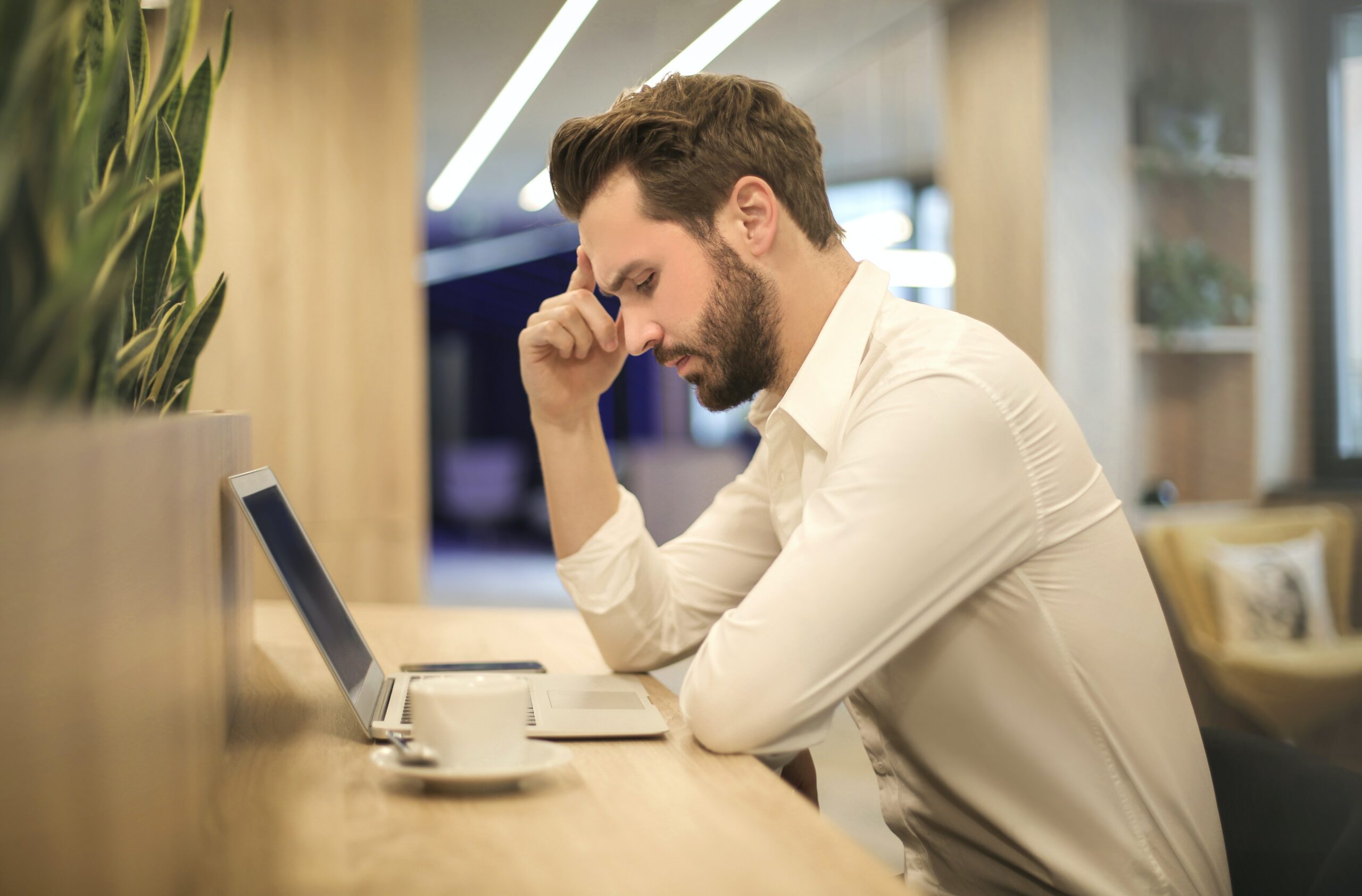 Perplexed man sitting at a desk wanting to know how to relieve stress at work.