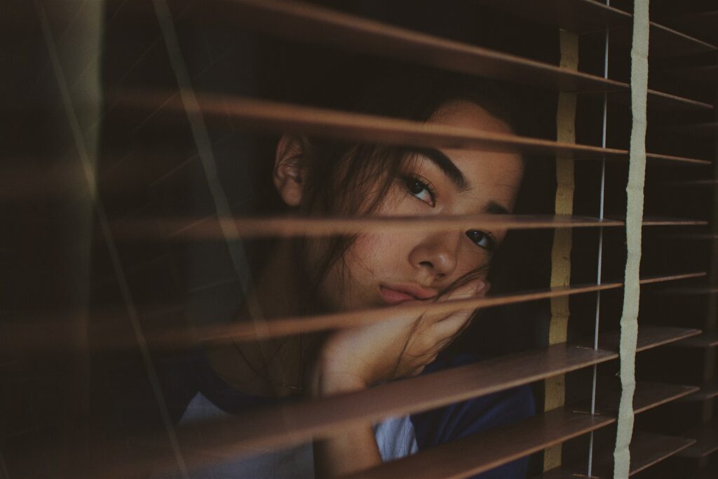 Women with the winter blues staring outside her window.