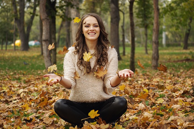 Beautiful girl siting outside in the fall leaves